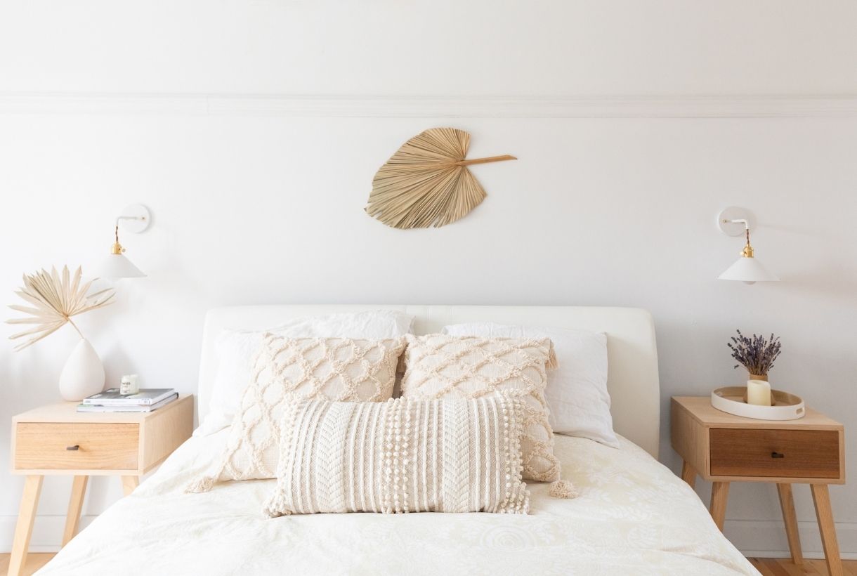 A white boho bedroom and bed with two nightstands