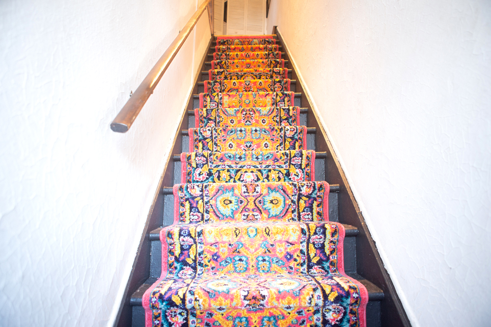 colourful new carpet runner on old wood stairs in an old house