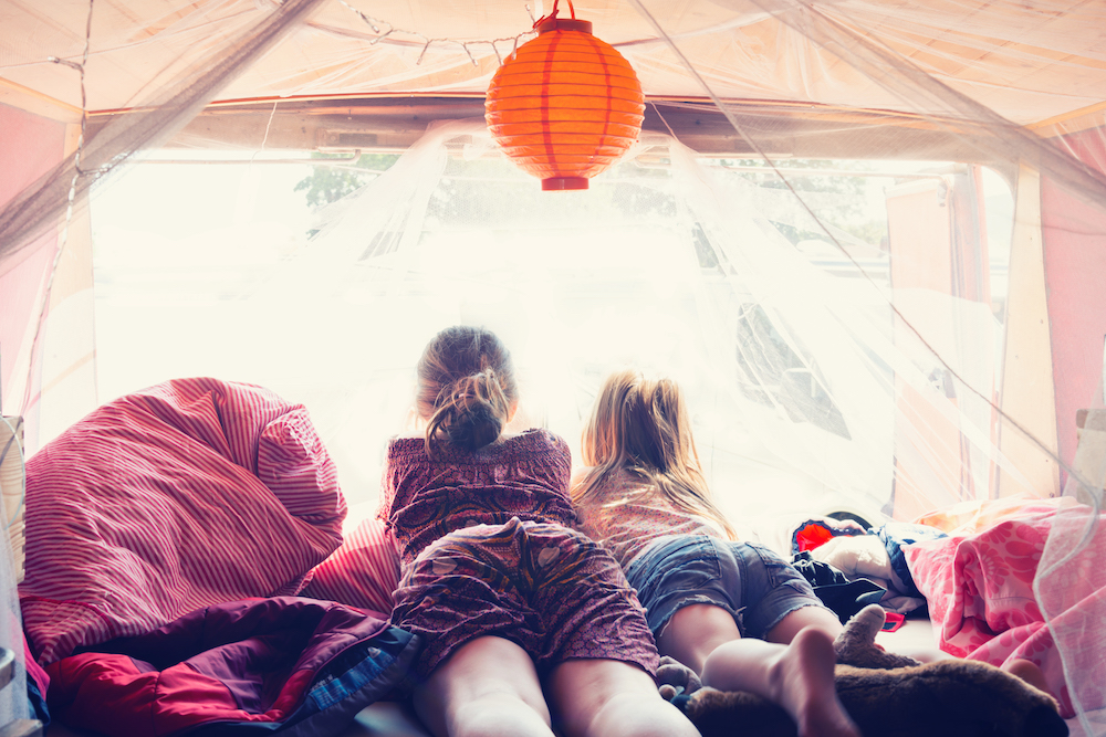 children look out of van with tulle curtains