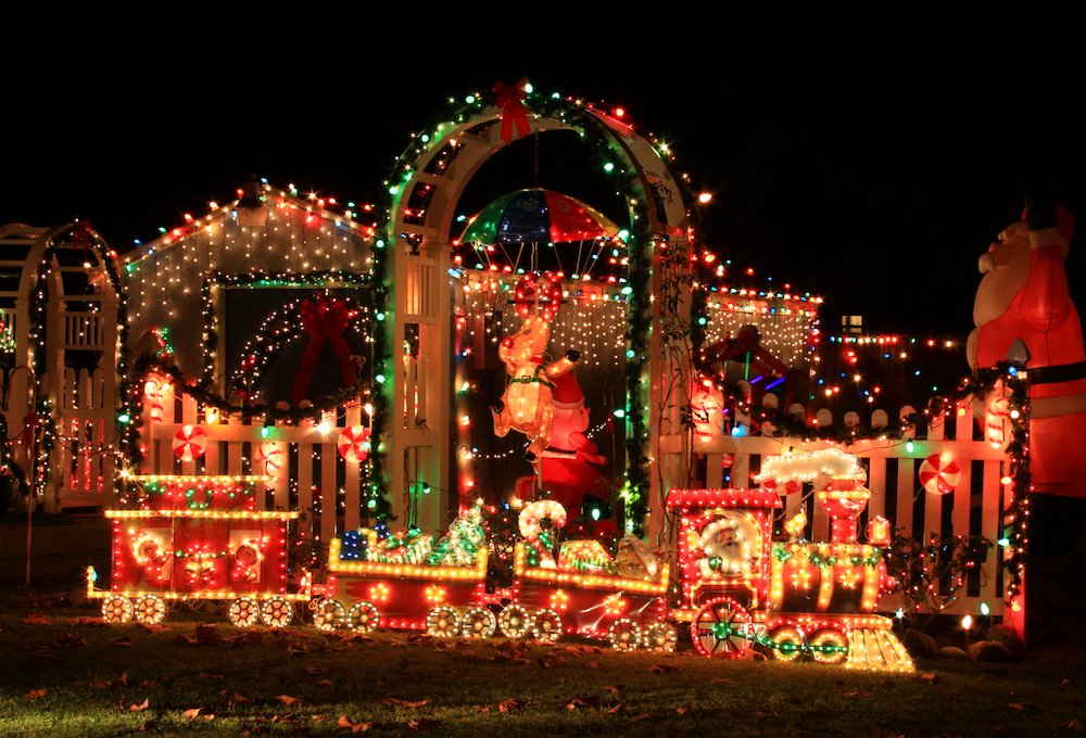 house with colourful christmas lights on home, fence and archways