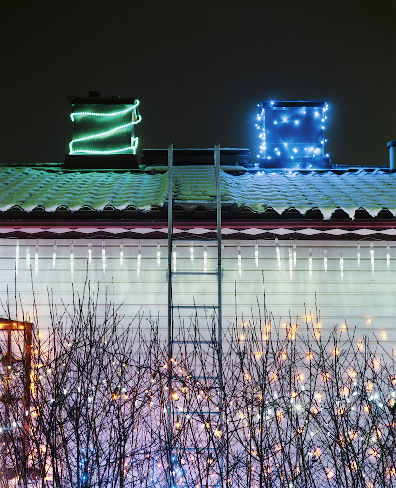 white house exterior with green and blue lights on chimneys