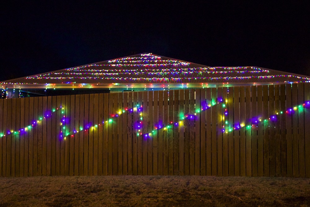 colourful lights on the roof and fence of house