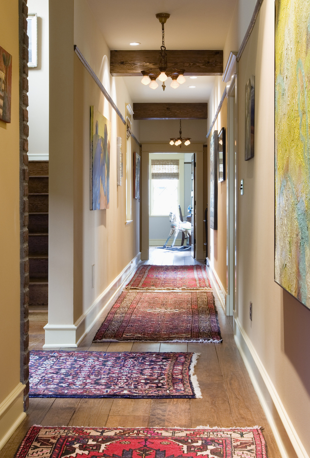 Lots of vintage carpets in the hallway of a home