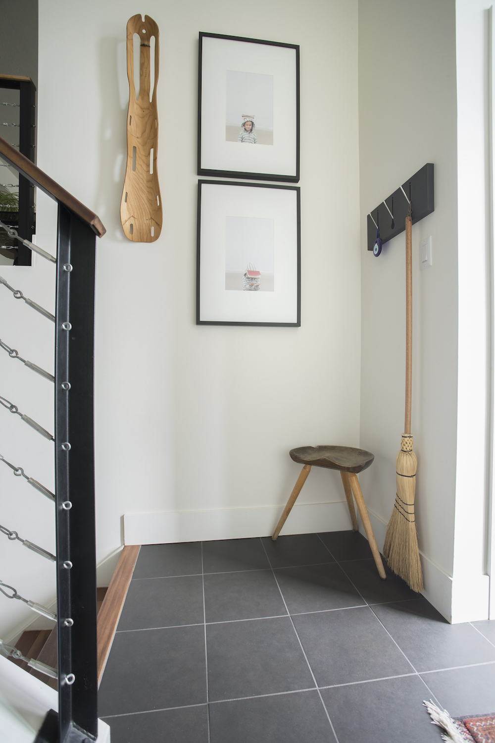 Corner of a hall with hooks for storage and a stool