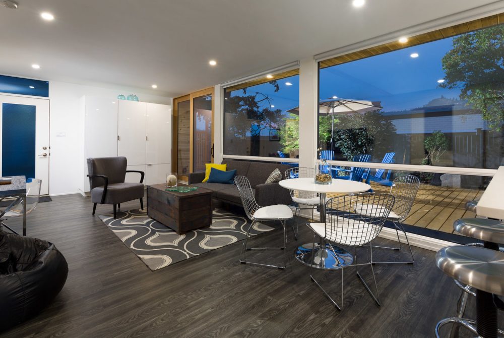 Inside a spacious storage container home with furniture and floor-to-ceiling windows