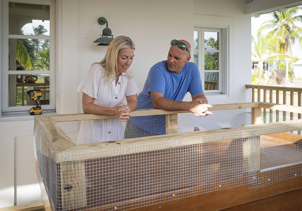 Bryan and Sarah Baeumler looking in through the top of a brooding pen.