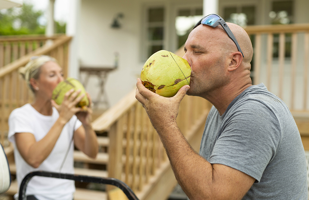 Bryan and Sarah Baeumler drinking coconut milk.