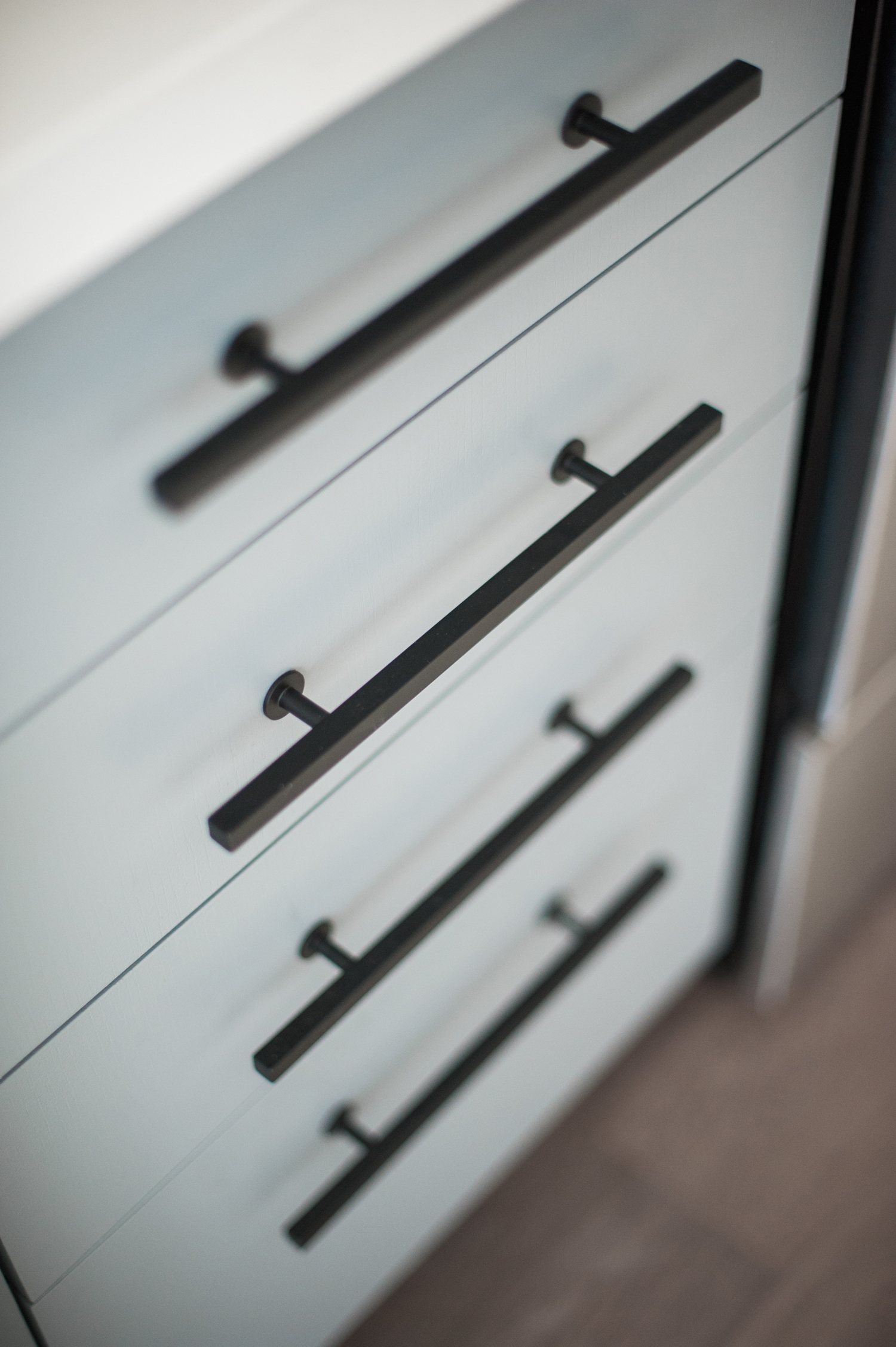 Light blue kitchen cabinets with modern black hardware.