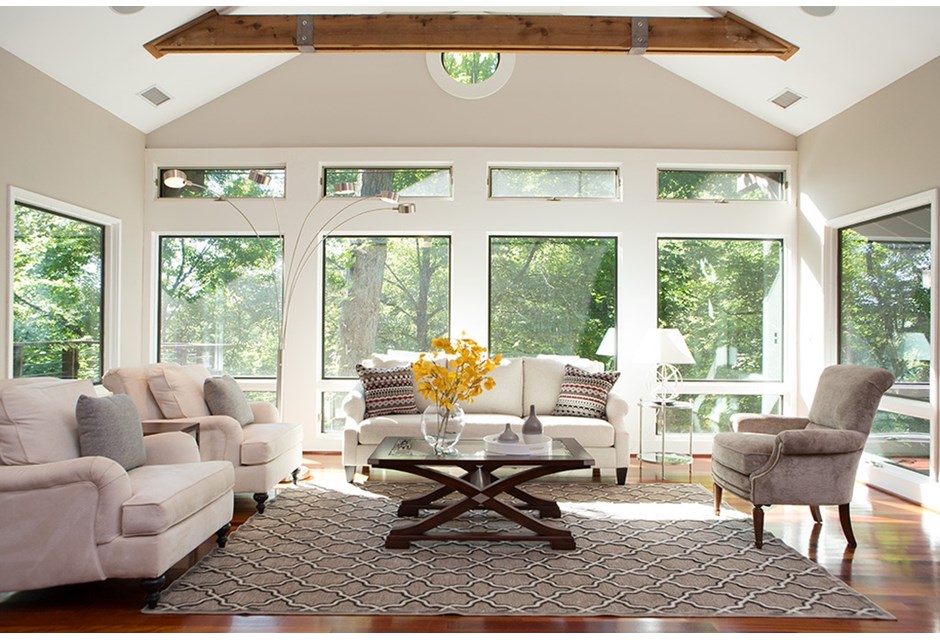 white living room with windows and beige couches and chairs