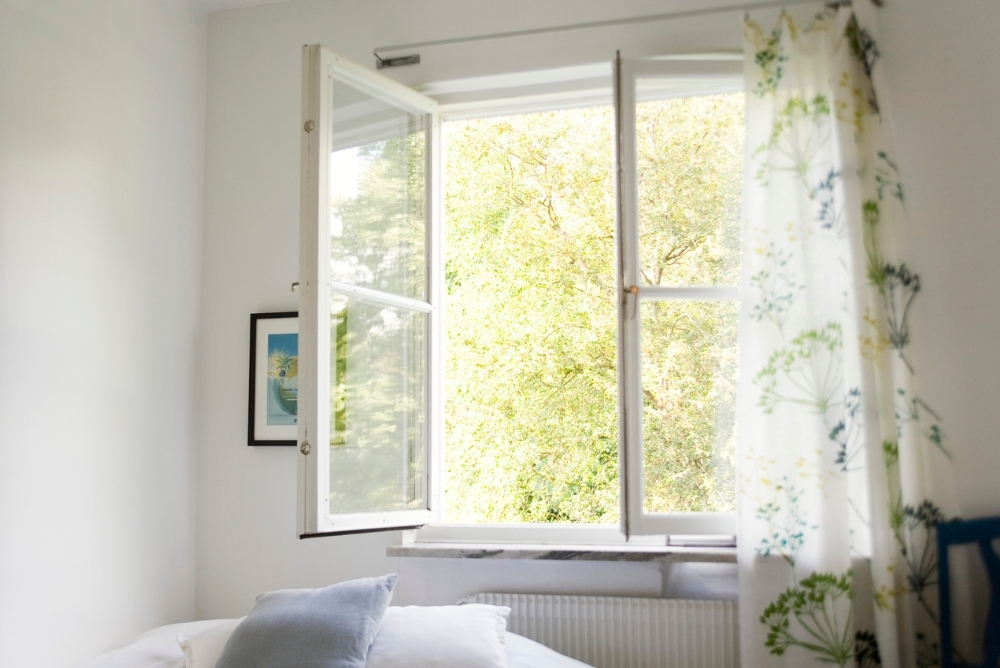 A white boho bedroom and bed with two nightstands