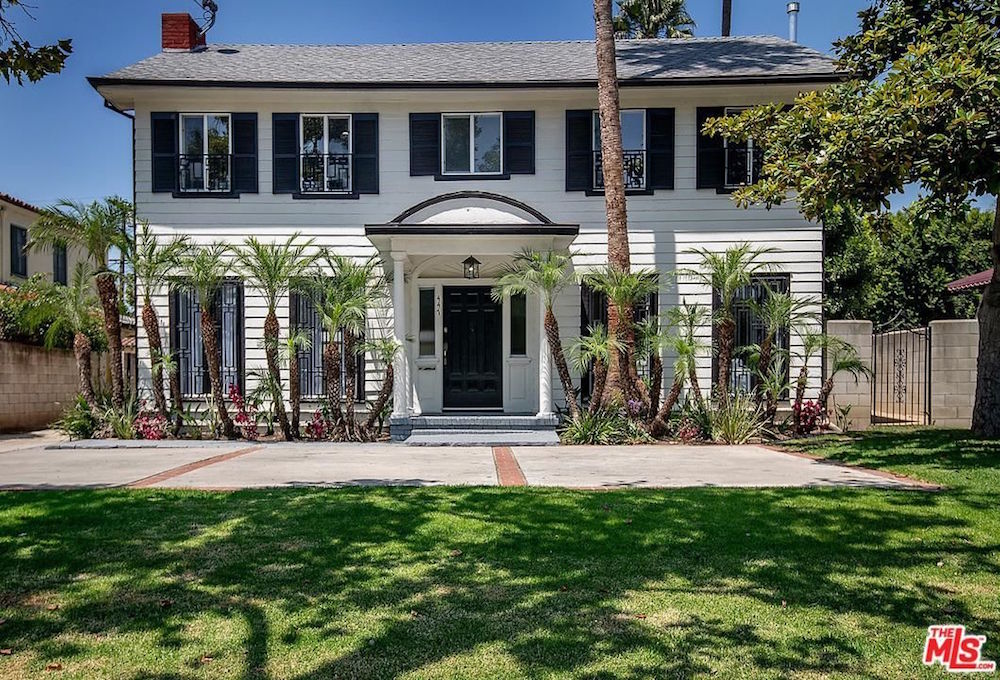 white house exterior with palm trees and green grass