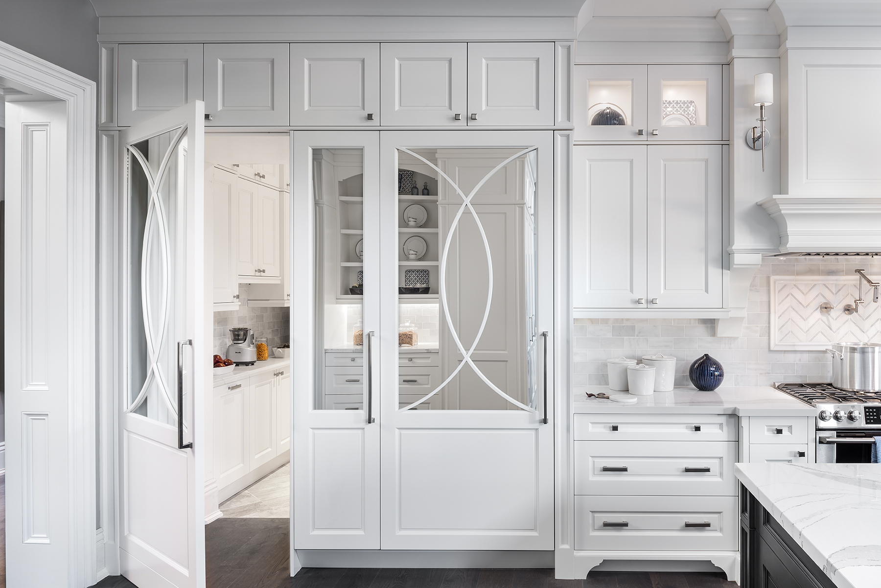 Modern white kitchen with mirrored cabinetry doors.