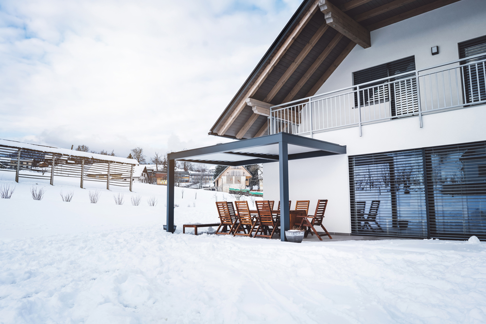 Large, modern house in the wintertime with patio