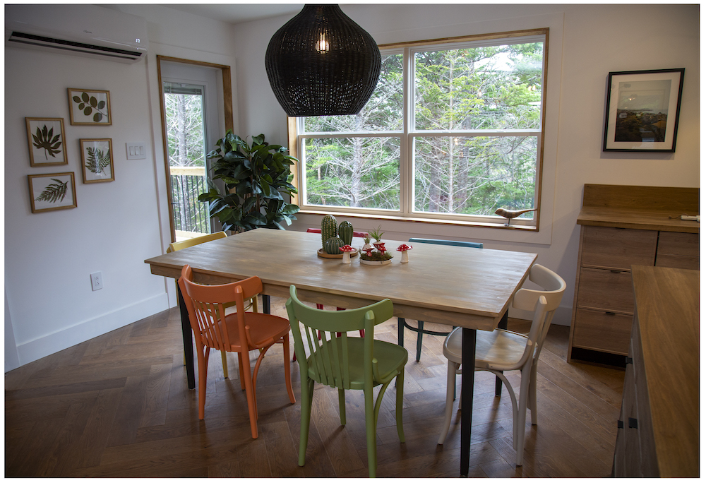 open-concept dining room with wood table and colourful chairs