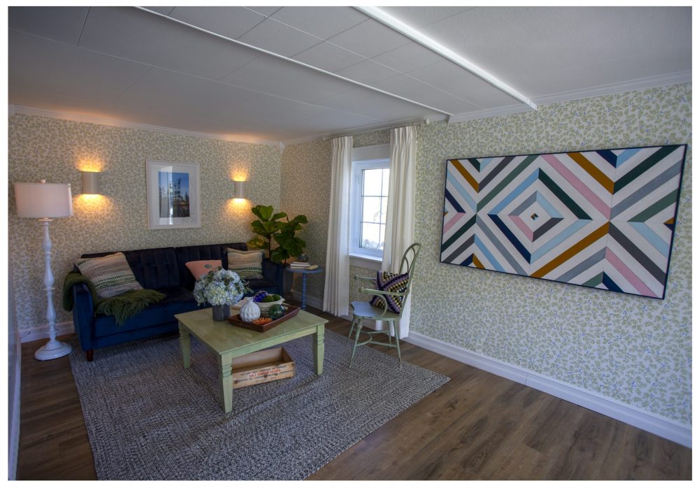 living room with blueberry wallpaper and blue couch