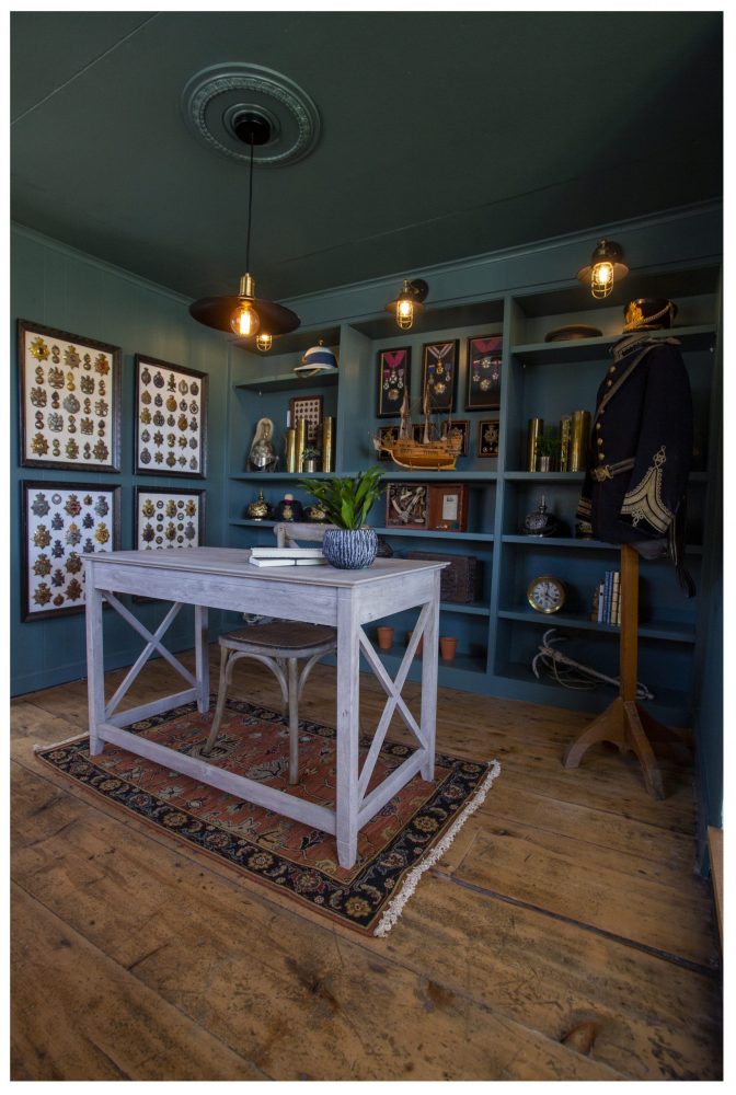 dark green study with nautical light fixtures and built-in shelves