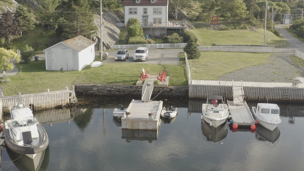 waterfront area with newly installed land and floating dock with docked dinghies