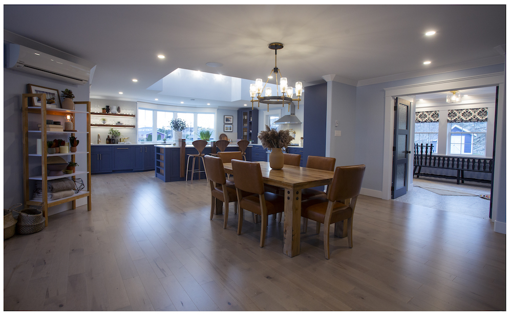 open concept dining room with wood dining table and kitchen in background