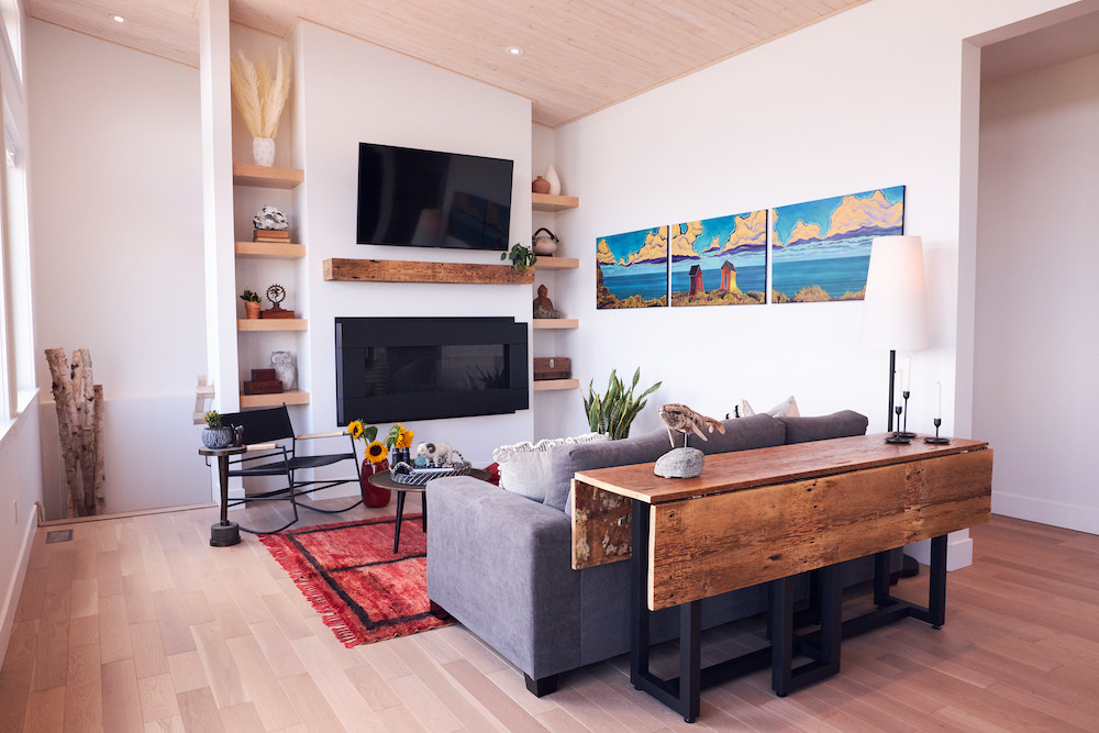 white living room with large fireplace and wood mantel