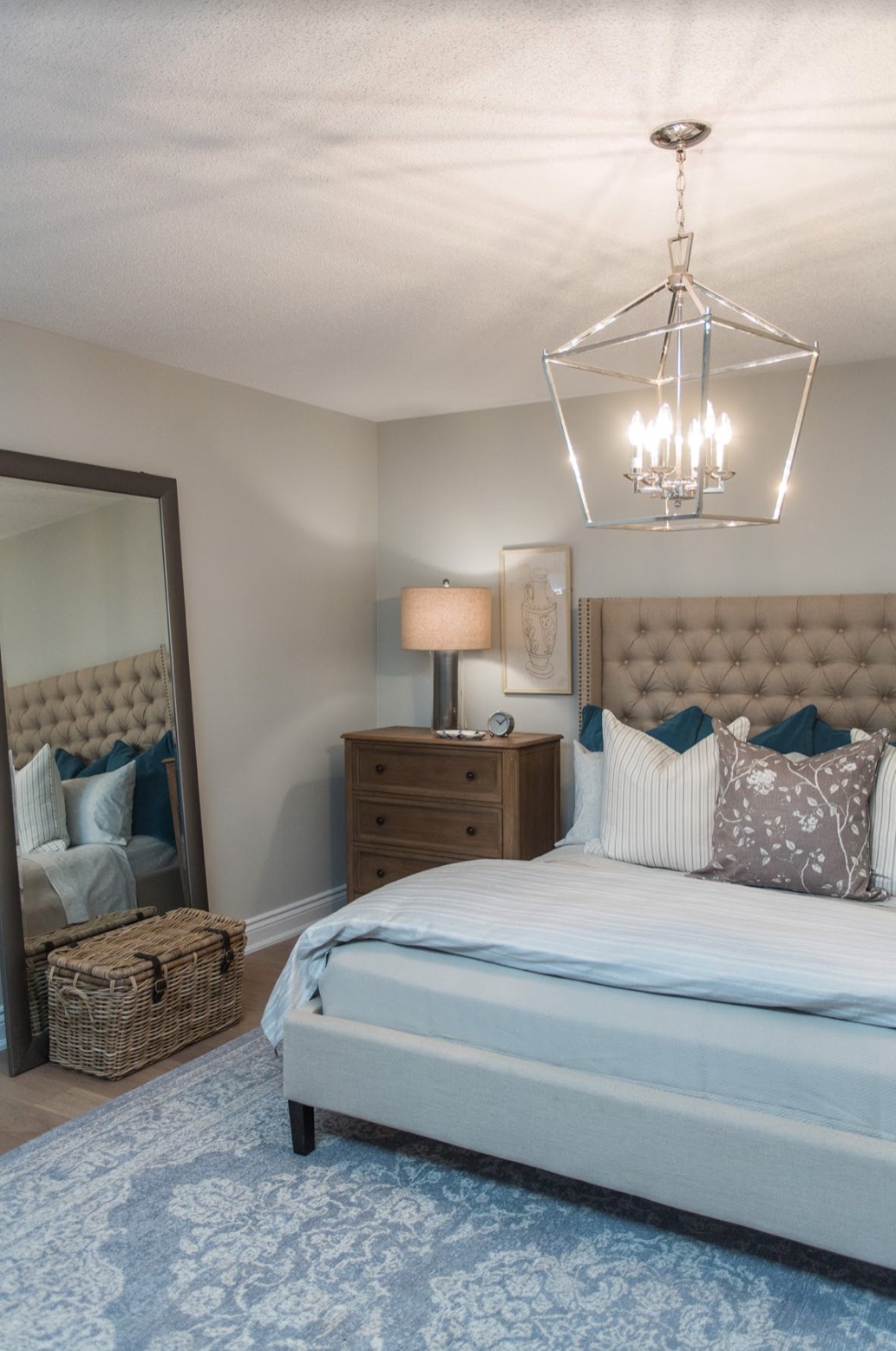 Bedroom with tufted headboard and blue area rug