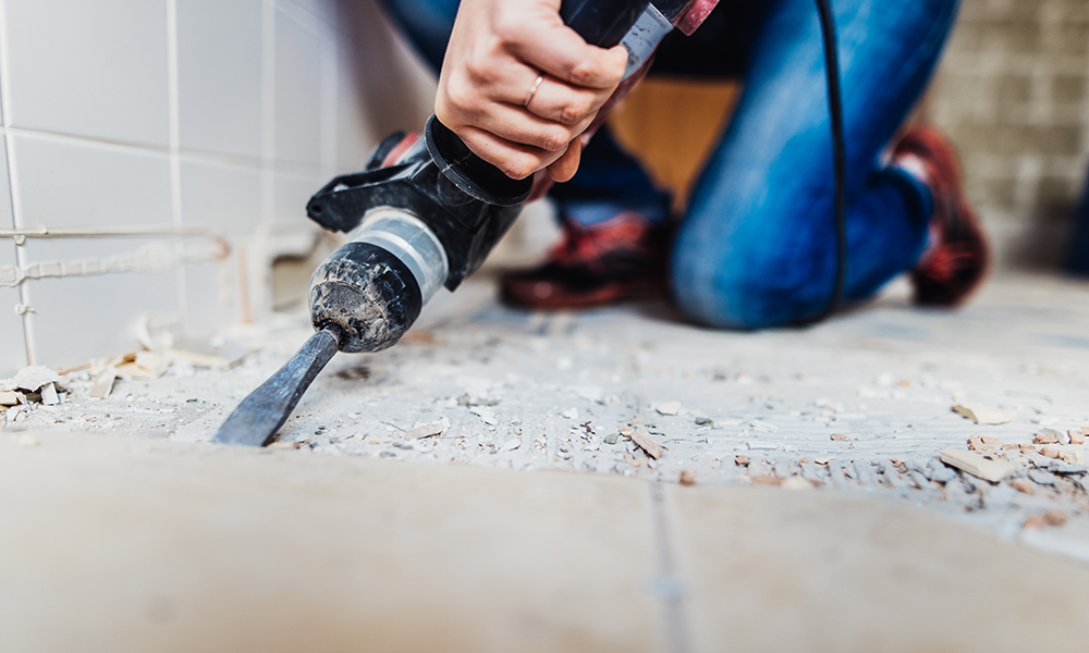 A woman taking up floor tiles