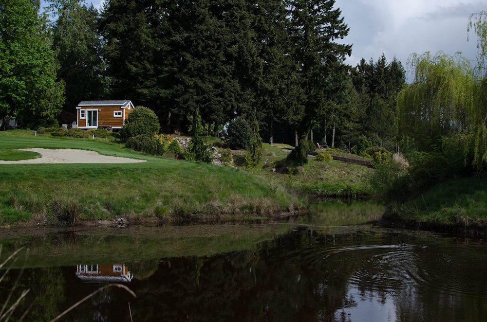 tiny home on grass near pond