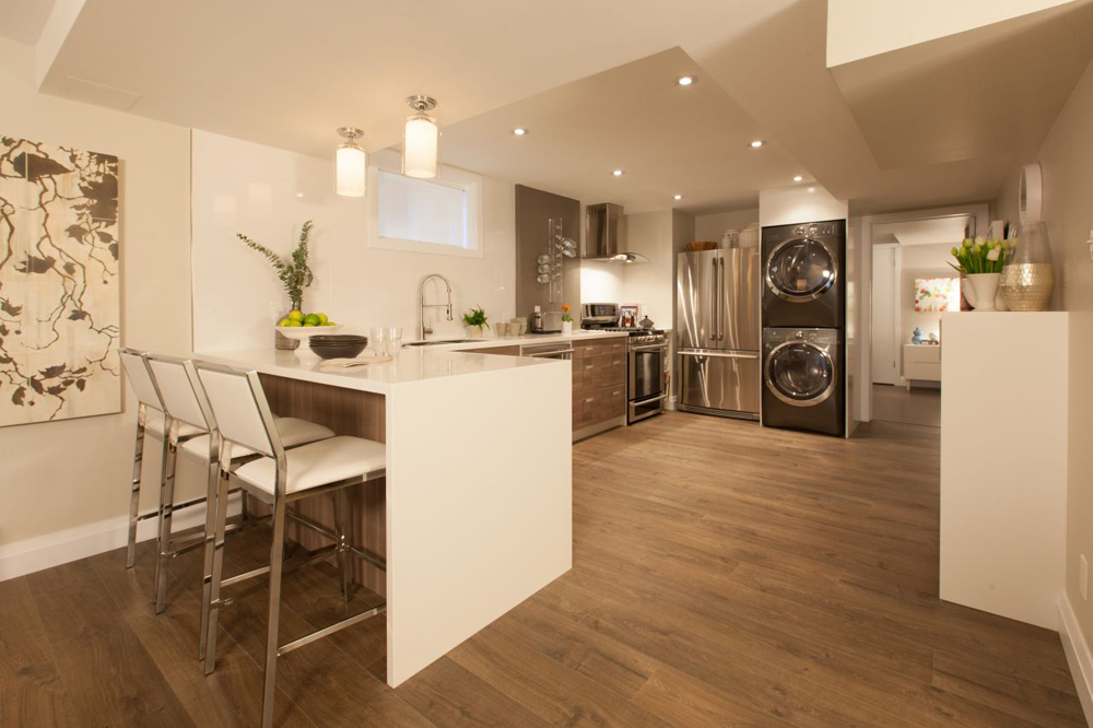 Basement apartment featuring a laundry unit in the kitchen.