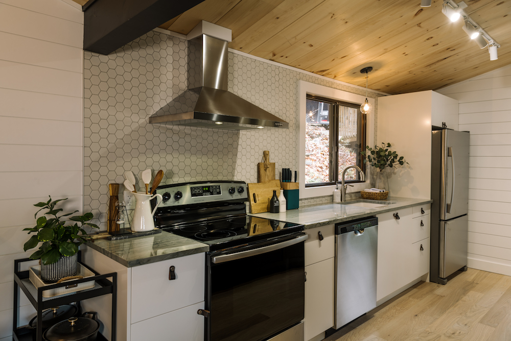 modern white kitchen with geometric backsplash and stainless steel appliances