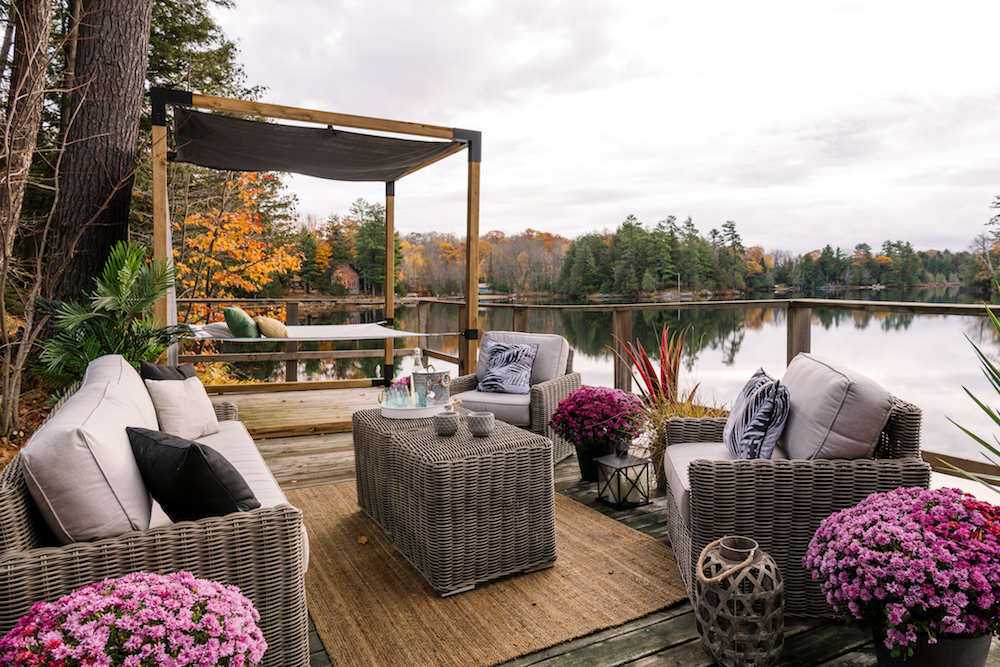 dock on lake with wicker furniture an pergola with hammock