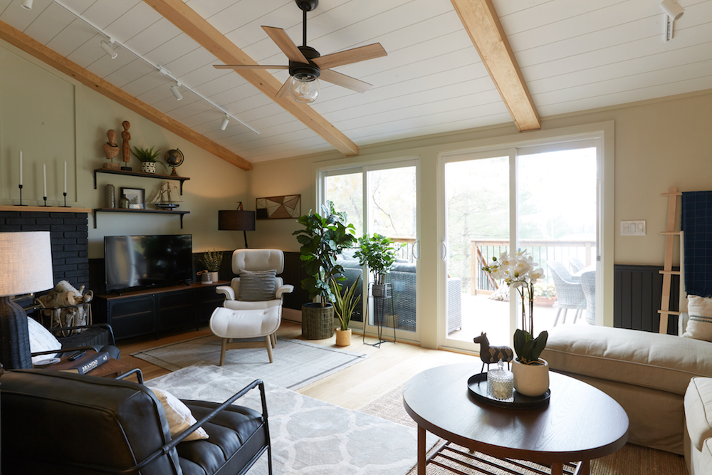 cozy cottage with black furniture and wood beams on white ceiling