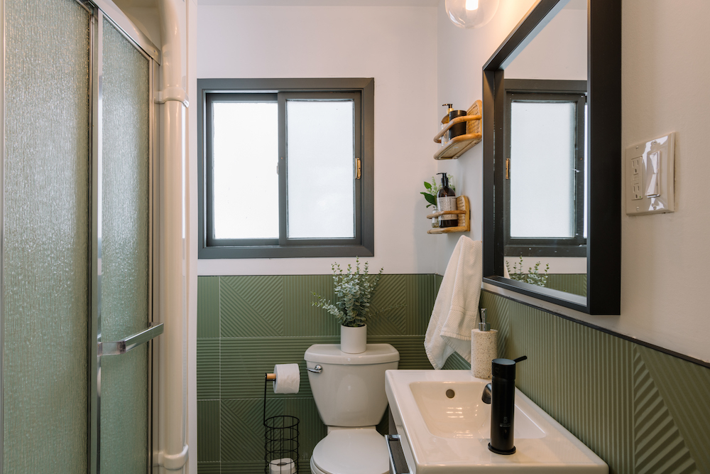 green and white bathroom with black fixtures