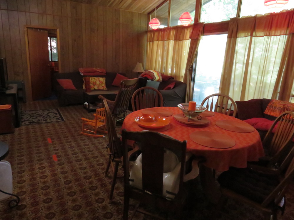 dark retro living and dining space with orange and wood accents