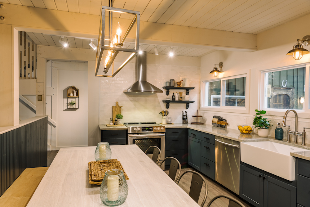 cozy white kitchen with blue lower cabinets and metallic hardware and finishes