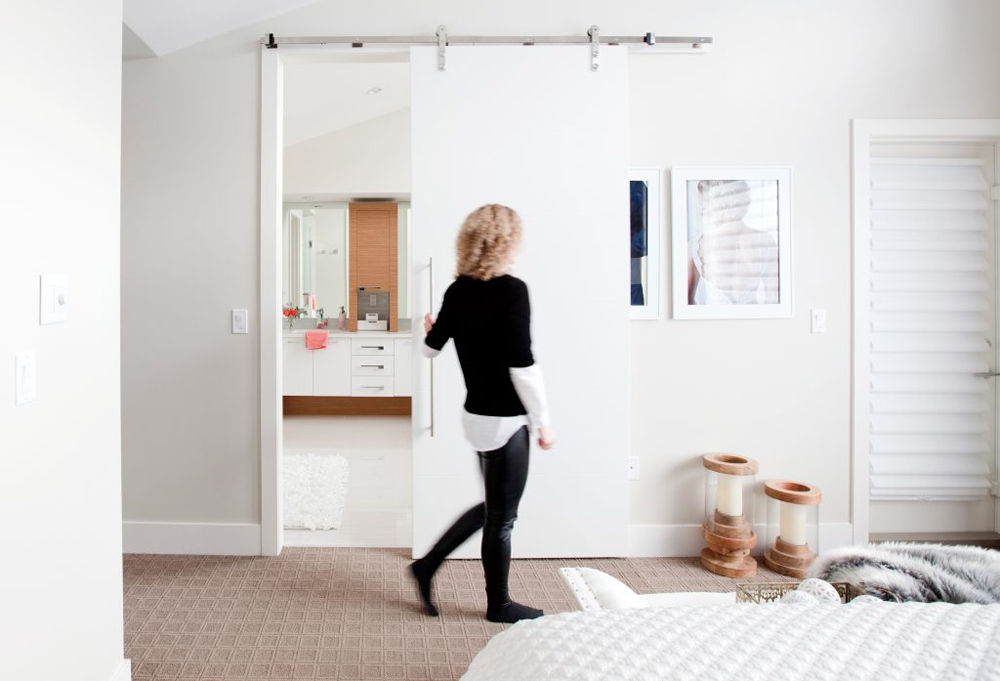 Woman opening pocket door on bathroom