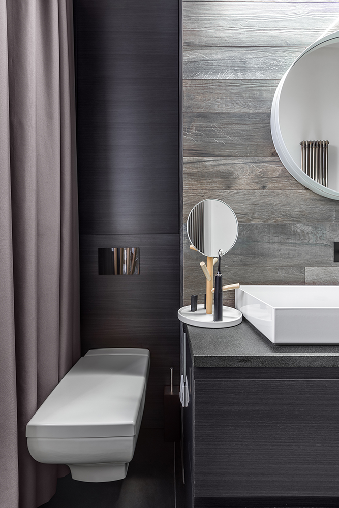 Wall-mounted toilet in black bathroom