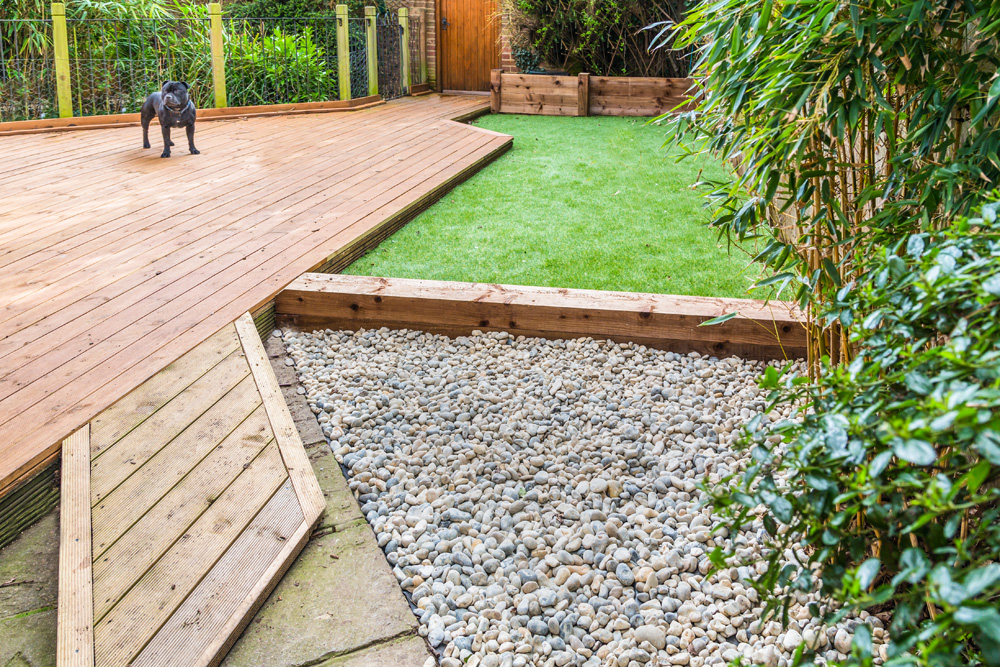 Landscaped backyard with a dog on a deck