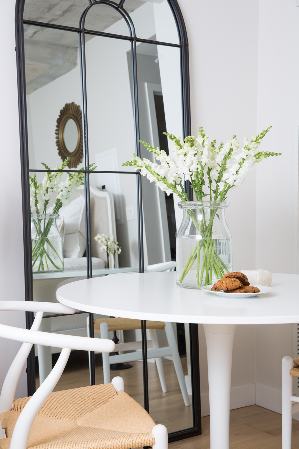 White dining nook with black bistro mirror