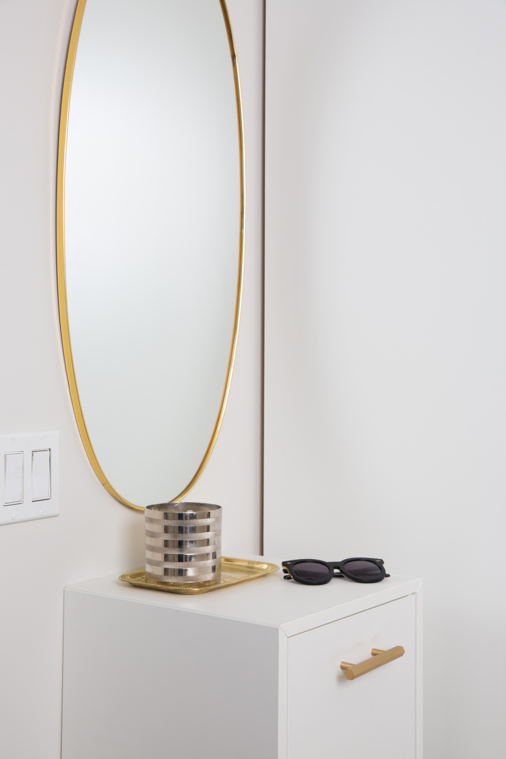 Floating console table under an oval mirror