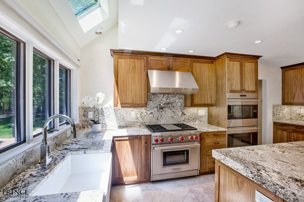 white kitchen with walnut cabinets and granite counters