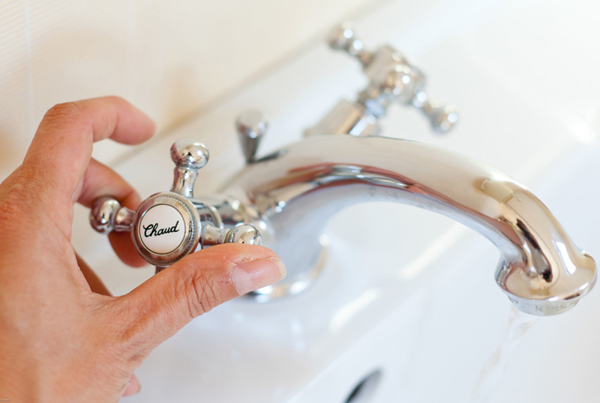 Woman turning off tap