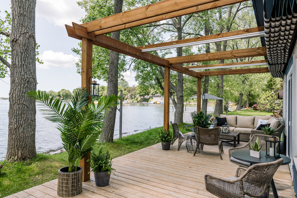 view of beach from cottage with open pergola and outdoor dining area