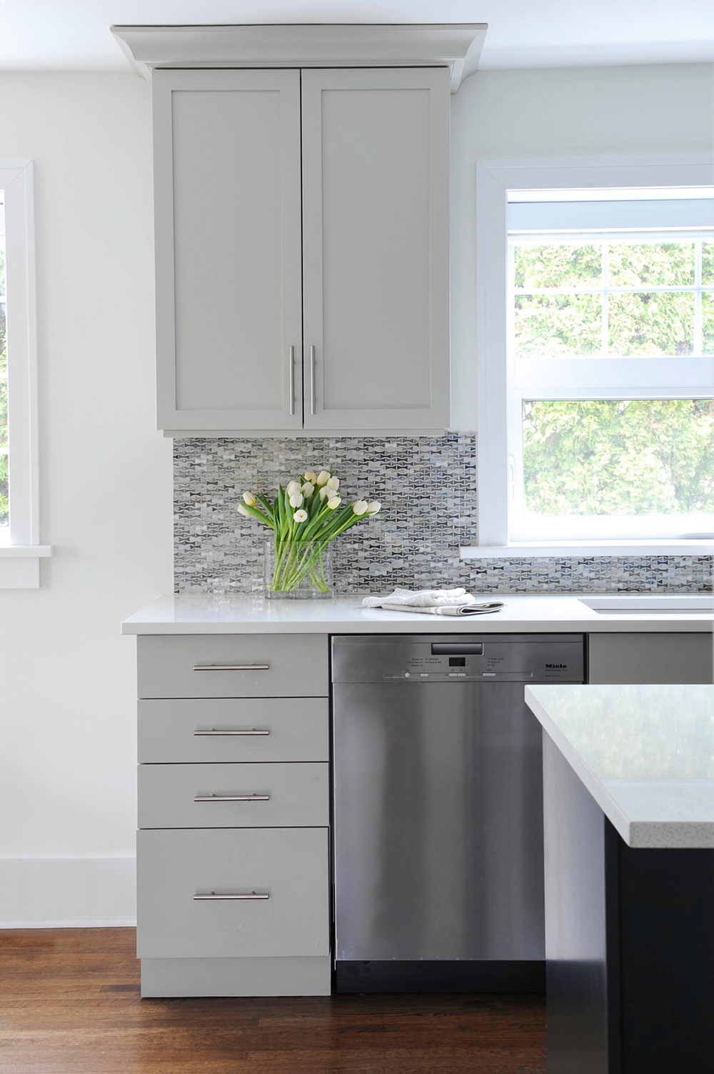 Grey kitchen cabinetry with shaker doors and stainless-steel pulls.