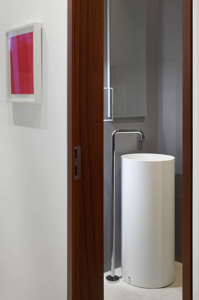 A contemporary cylindrical vanity in a powder room