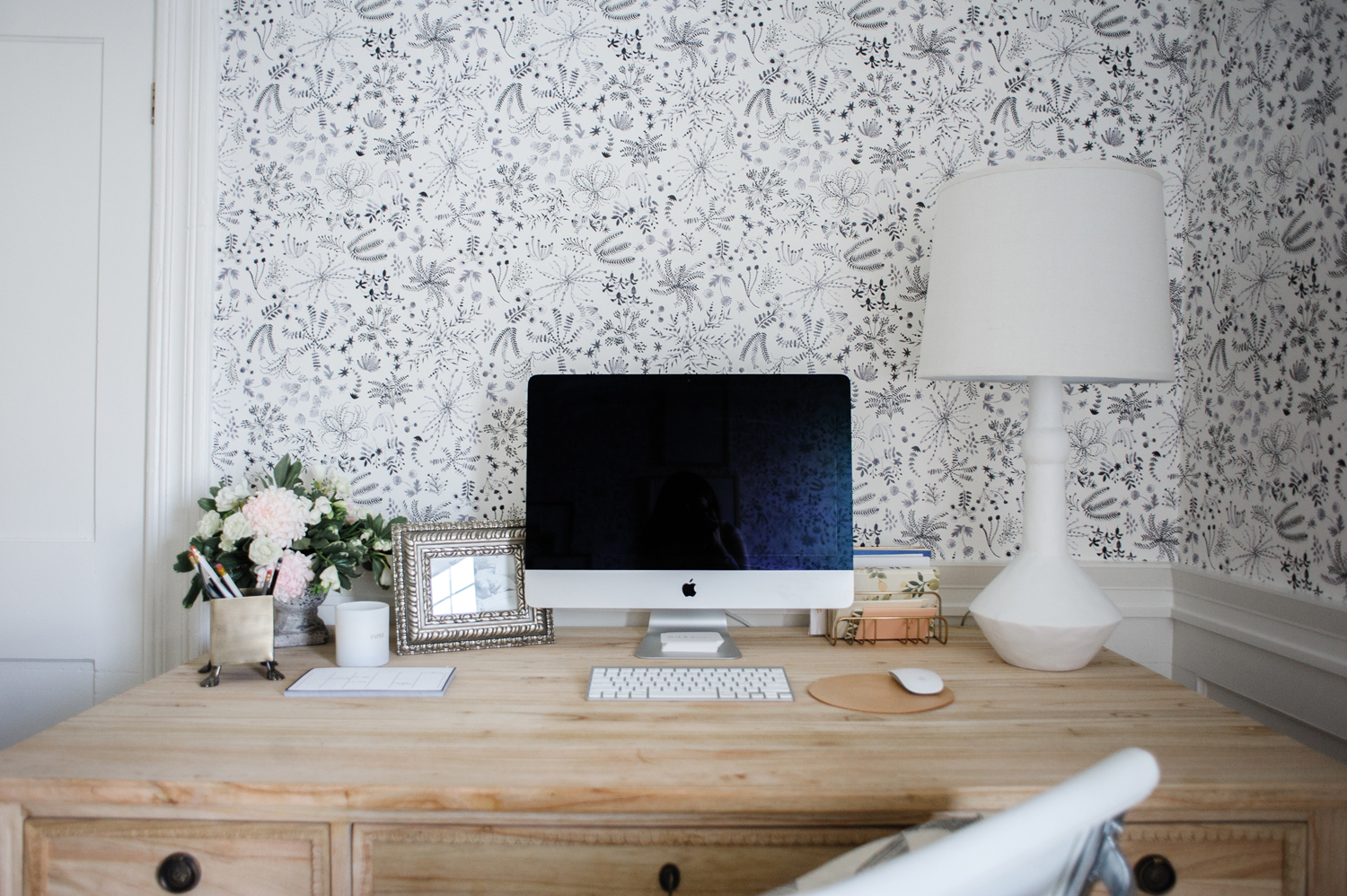 Desktop computer on raw wood desk with wallpaper background