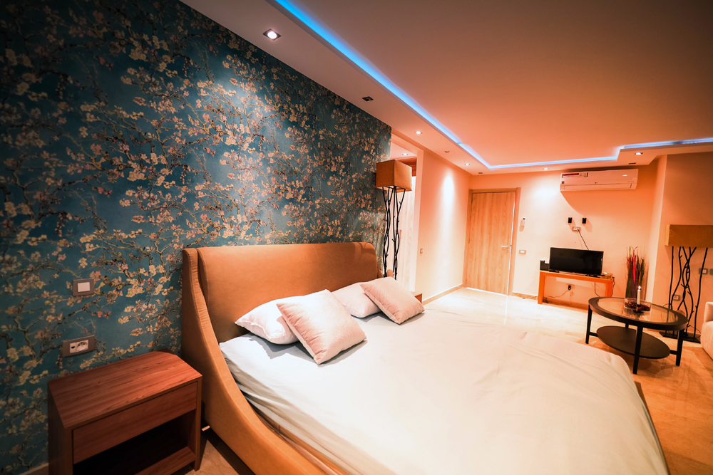 a dark basement bedroom with a bed and nightstand