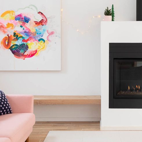 A brightly lit living room with a fireplace and light wood flooring