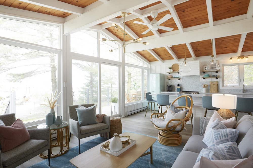 Floor-to-ceiling windows with white wooden beams in furnished living room