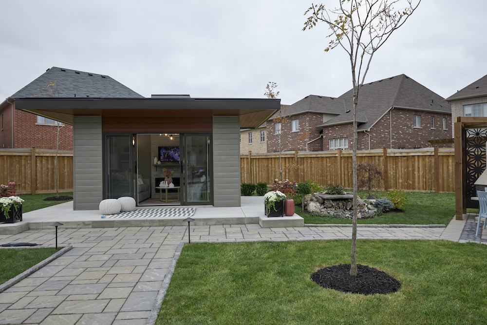 A year-round backyard sunroom is loaded with a fireplace, television and plenty of seating