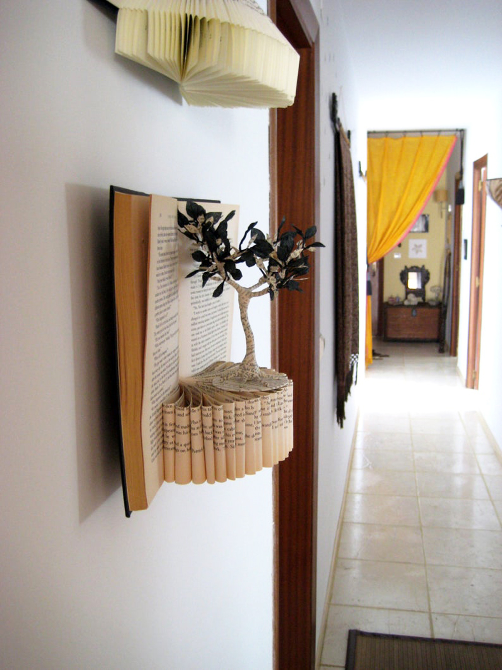 A book sculpture hanging on a wall in the shape of the Tree of Life