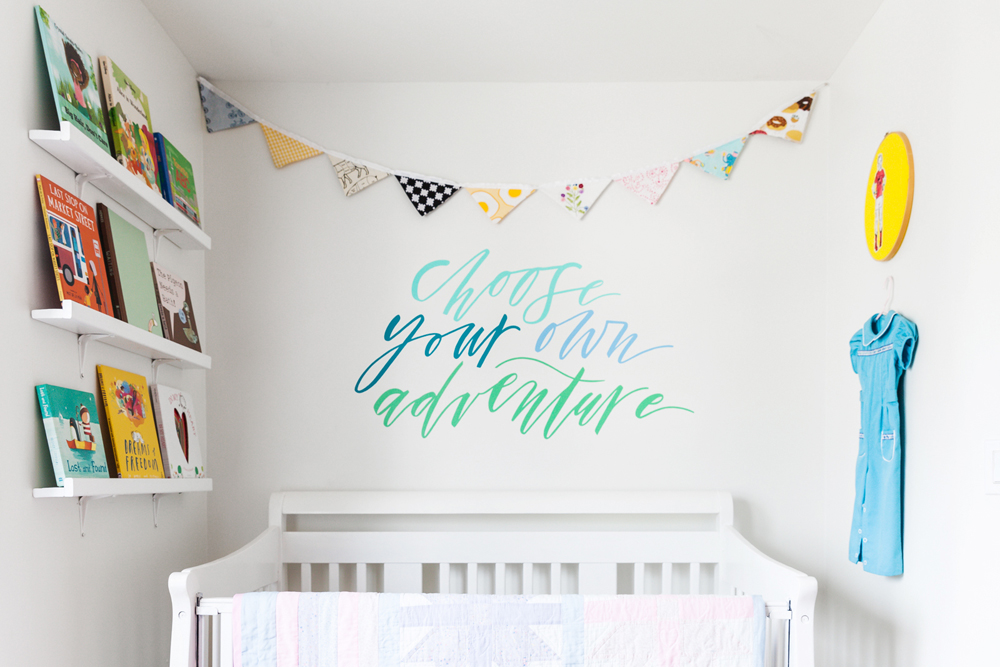 A whimsical white nursery with books displayed on open shelving